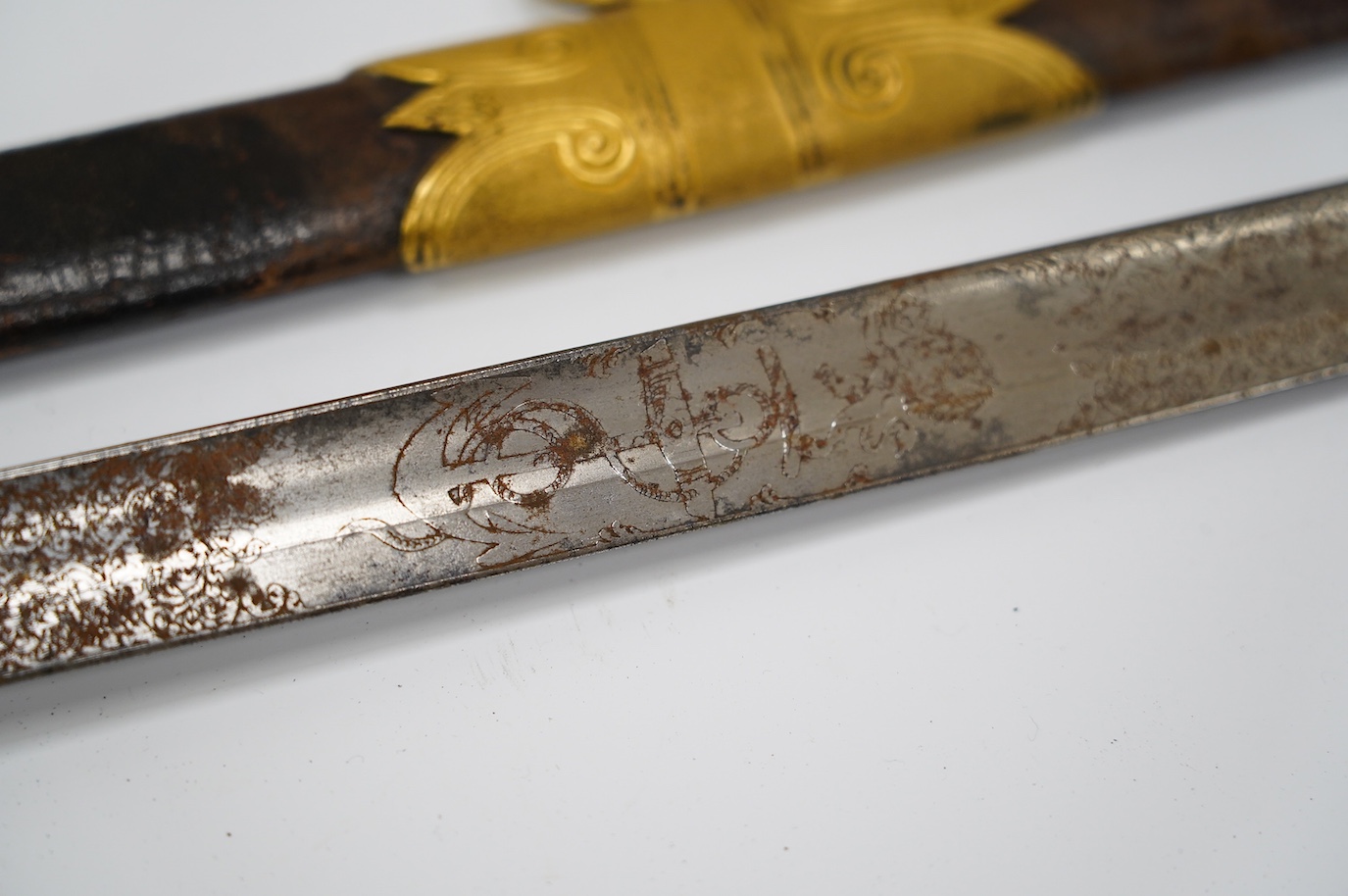 An East India Company naval officer's sword, blade by H. Wart, etched with East India Company device and foliage, regulation gilt, brass hilt with EIC device, white fish skin covered grip, in its leather scabbard with gi